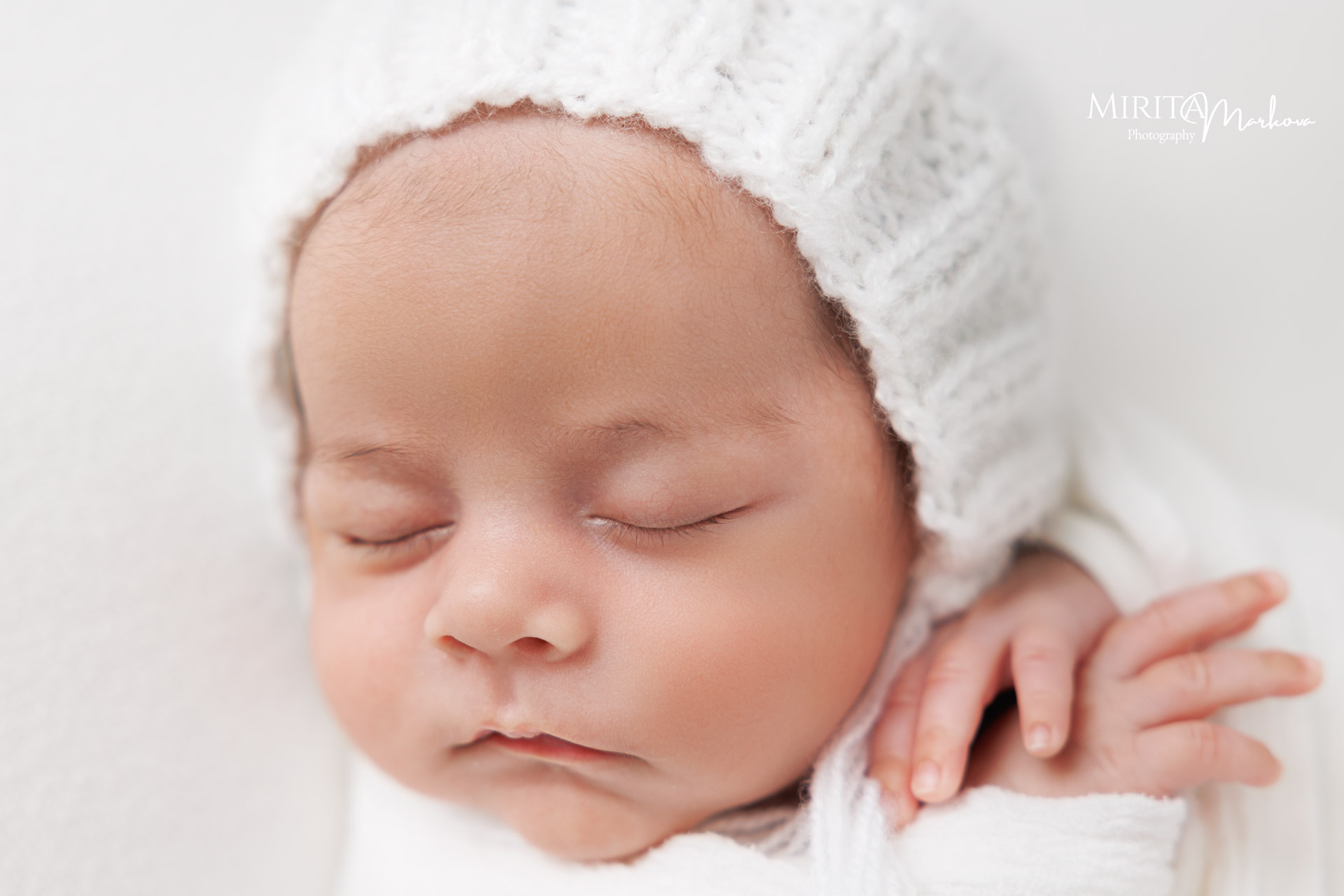 Новородено бебе с бяла плетена шапка.