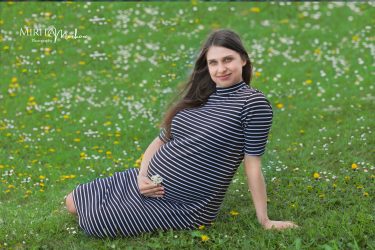 Красива бременна мама в парка.